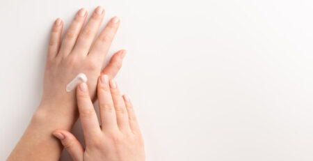 Care cosmetic concept. Woman applying cosmetic cream on hands, i