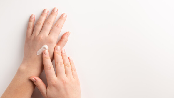 Care cosmetic concept. Woman applying cosmetic cream on hands, i