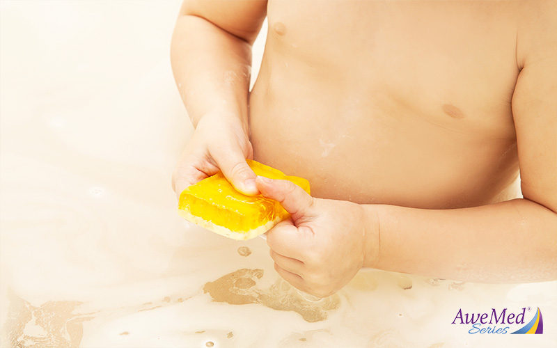 baby holding yellow soap bar